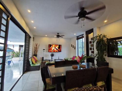 a living room with a table and a ceiling fan at Casa condominio santa ana in Flandes