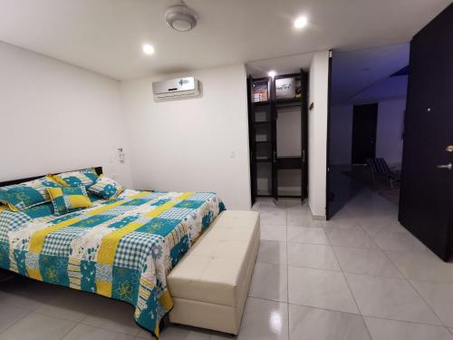 a bedroom with a bed with a colorful comforter at Casa condominio santa ana in Flandes