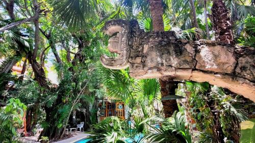 a building with a statue in front of trees at Eco-hotel El Rey del Caribe in Cancún