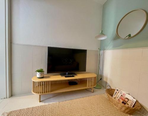 a living room with a television on a table at Casa da Aldeia in Bensafrim