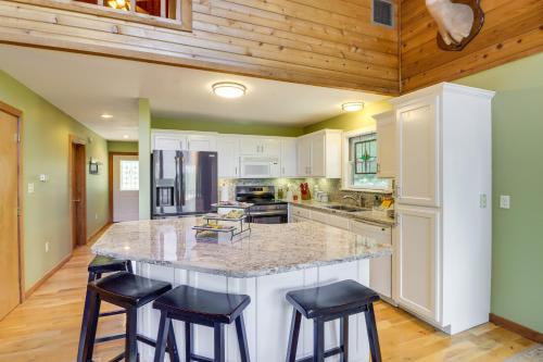 a kitchen with a large island with bar stools at Peaceful Greers Ferry Cabin with Deck and Lake View! in Fairfield Bay