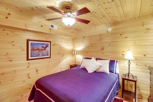 a bedroom with a bed and a ceiling fan at Peaceful Greers Ferry Cabin with Deck and Lake View! in Fairfield Bay