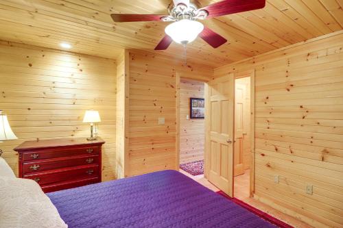 a bedroom with a bed and a ceiling fan at Peaceful Greers Ferry Cabin with Deck and Lake View! in Fairfield Bay