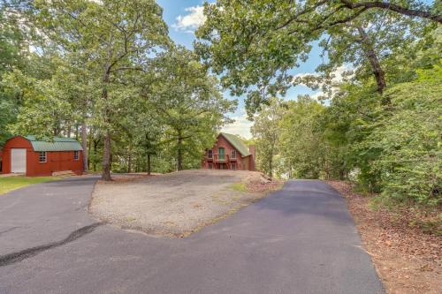 a driveway leading to a red barn and a house at Peaceful Greers Ferry Cabin with Deck and Lake View! in Fairfield Bay