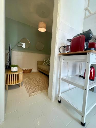 a kitchen with a table with a red appliance on it at Casa da Aldeia in Bensafrim