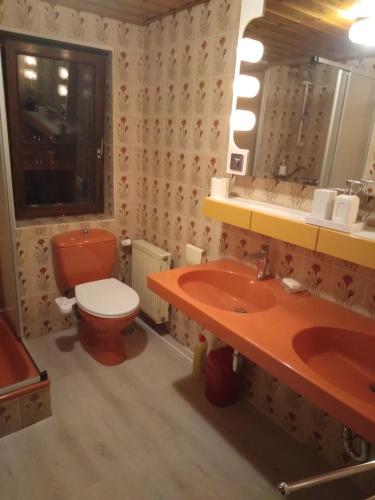 a bathroom with a red toilet and a sink at 100 Stufen über dem Rhein in Oberwesel