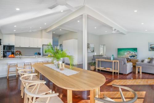 a kitchen and living room with a wooden table and chairs at Harbour View - 5 McDonald Place in Evans Head