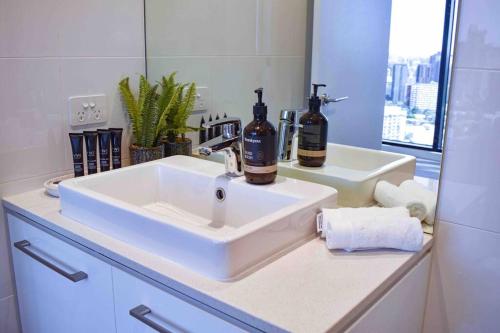 a bathroom sink with two bottles of wine on it at Premier 3 Bedroom Apartment in Southbank in Melbourne
