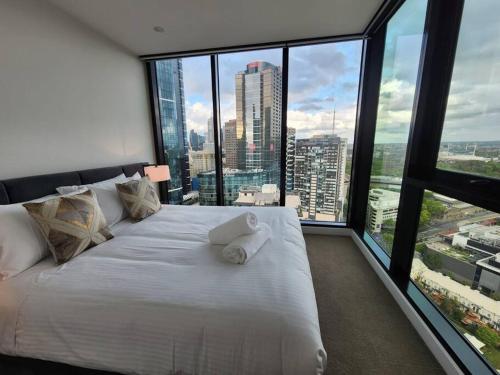 a large white bed in a room with large windows at Premier 3 Bedroom Apartment in Southbank in Melbourne