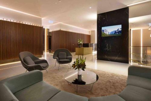 a lobby with a couch and chairs and a tv at Premier 3 Bedroom Apartment in Southbank in Melbourne