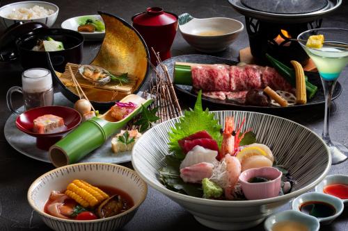 a table topped with plates of food and bowls of food at Shogetsu Grand Hotel in Jozankei