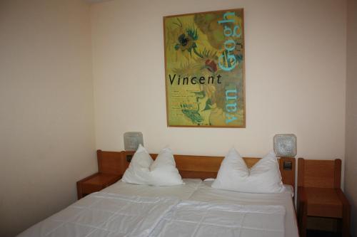 ein Bett mit weißen Kissen und ein Gemälde an der Wand in der Unterkunft FeWo 238 in Winterberg