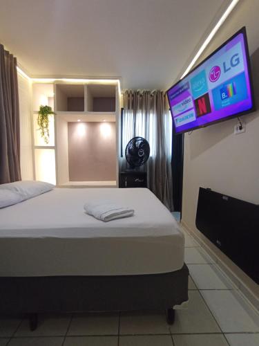 a bedroom with a bed and a flat screen tv at Praia do Bessa, Caribessa - Quarto Privativo - Conforto, Paz e Sossego, excelente para descansar, trabalhar ou estudar in João Pessoa