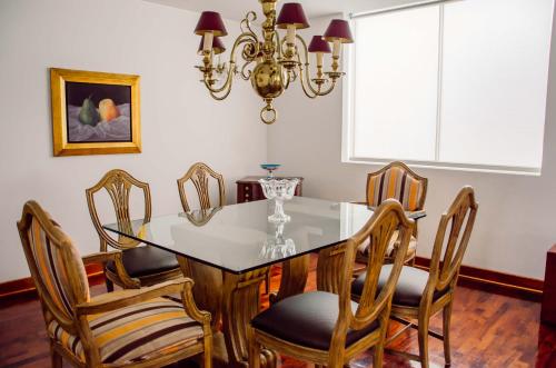 a dining room table with chairs and a chandelier at Ana Frank Boutique Hotel in Lima
