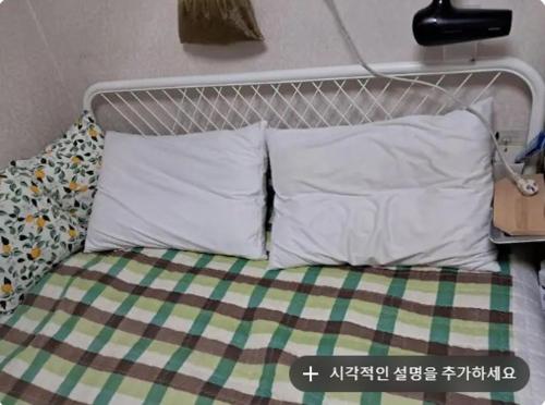 a bed with two pillows and a headboard at Chanel House Seoul in Seoul