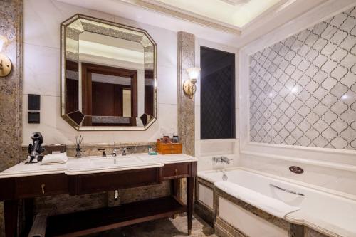 a bathroom with a tub and a sink and a mirror at Shanghai Donghu Hotel - Shanghai Style Garden House in Shanghai