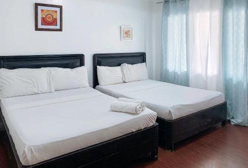 two beds sitting next to each other in a room at RedDoorz at LFamili Hotel Boracay in Boracay