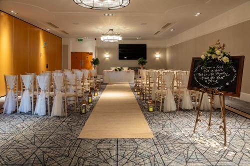 a banquet hall with a chalkboard and tables and chairs at Holiday Inn Newcastle Gosforth Park by IHG in Newcastle upon Tyne