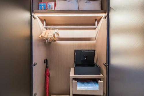 a walk in closet with a door open with a tv at Beijing Guangxi Hotel in Beijing