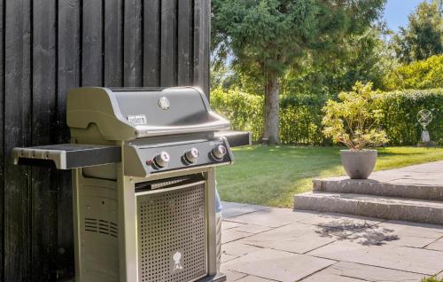 a grill sitting on a patio next to a fence at Beautiful Home In Dronningmølle in Dronningmølle