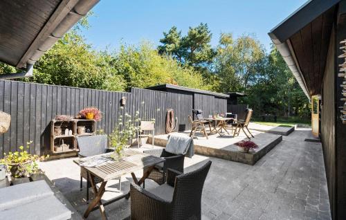a patio with a table and chairs and a fence at 4 Bedroom Beautiful Home In Nykøbing Sj in Nykøbing Sjælland