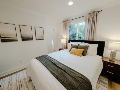 a white bedroom with a large bed and a window at Serene Escape 2BD Private Patio & Firepit near Stanford in Menlo Park