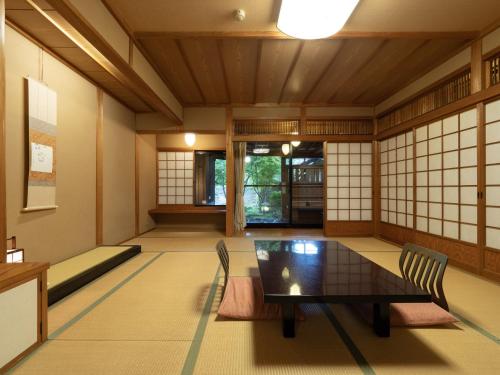 a japanese room with a table and chairs at 天空の湯屋 山荘 華柚 in Oguni