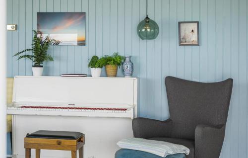 a living room with a chair and a piano at Amazing Home In Føllenslev With Kitchen in Føllenslev
