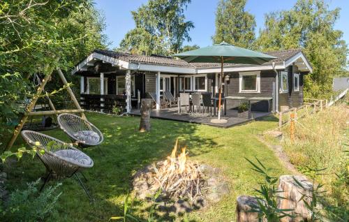 a small house with a fire in the yard at Holiday Home Tværvangen in Ebeltoft
