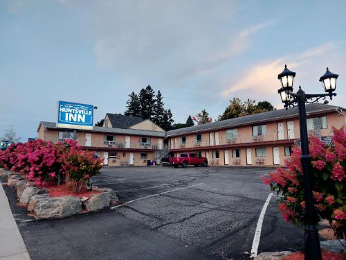 a hotel parking lot with a sign for a inn at Huntsville Inn in Huntsville