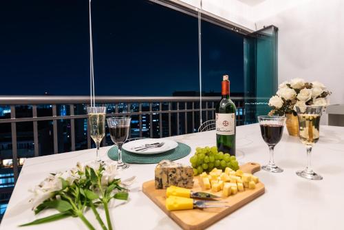 a table with a bottle of wine and cheese and wine glasses at Apartamento luxuoso 178 São João in Sao Paulo