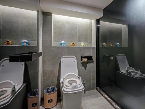 a bathroom with a toilet and two urinals at Mehood Lestie, Xiamen Zhongshan Road Pedestrian Street in Xiamen