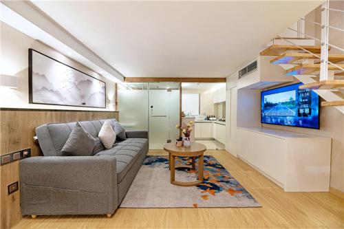 a living room with a couch and a tv at Mehood Lestie, Xiamen Zhongshan Road Pedestrian Street in Xiamen