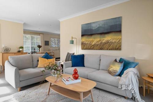 a living room with a couch and a table at Magnolia Cottage - Your private Bowral getaway! in Bowral