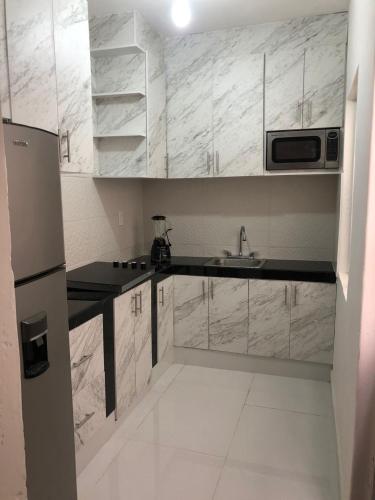 a small kitchen with a sink and a microwave at casa jireh in Santa Cruz Huatulco
