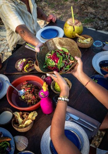 a group of people sitting at a table with food at Bo'a Vida Rote in Nembrala