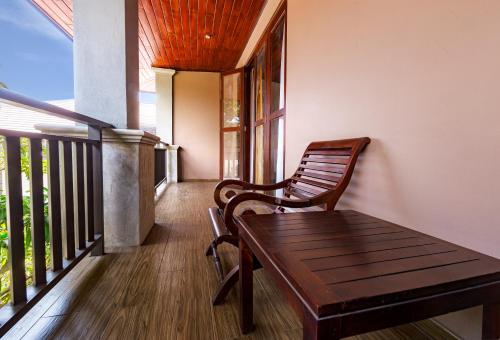 a wooden bench sitting on the porch of a house at The Full Moon Hotel Katunayake in Katunayake
