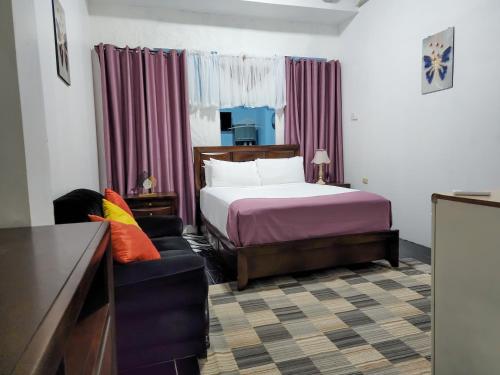 HopewellにあるSky Beach Hotelのベッドとソファのあるホテルの部屋
