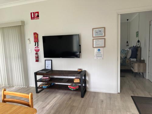 a living room with a flat screen tv on a wall at Blueberry Hills On Comleroy Farmstay - Self-Contained Cottages in Kurrajong