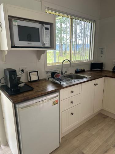 a kitchen with a sink and a microwave at Blueberry Hills On Comleroy Farmstay - Self-Contained Cottages in Kurrajong
