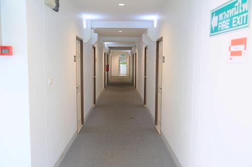 an empty hallway in a building with white walls at La VIVA Hotel in Buriram