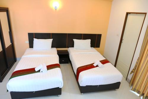 two beds in a hotel room with white sheets at La VIVA Hotel in Buriram