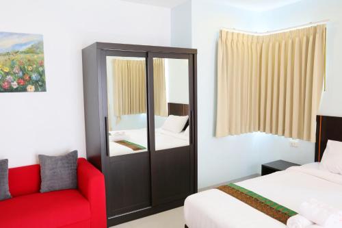 a bedroom with a mirror and a red couch at La VIVA Hotel in Buriram