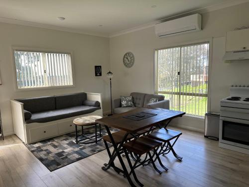 a living room with a couch and a table at Blueberry Hills On Comleroy Farmstay - Self-Contained Cottages in Kurrajong