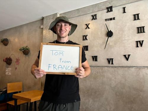 a man is holding a sign that says turn from france at Doze Hostel in Chiang Mai