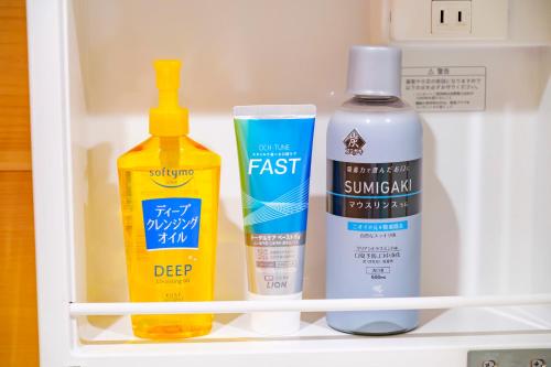 a shelf with two bottles of cleaning products in a refrigerator at UMIOTO log in Higa