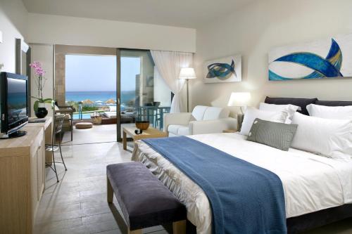 a bedroom with a large bed and a living room at Aquagrand Artistic Luxury Beach Resort - Adults Only in Líndos