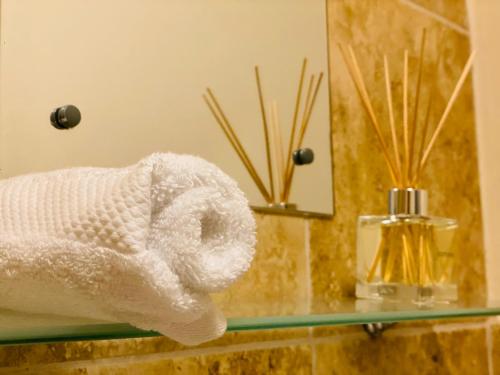 a roll of white towels on a counter in a bathroom at GB Relocations Ltd - Award Winning Merridale Executive Apartment, Free Parking, Free WiFi, Free Netflix in Wolverhampton