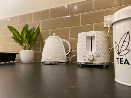 two toasters and a tea kettle on a counter at GB Relocations Ltd - Award Winning Merridale Executive Apartment, Free Parking, Free WiFi, Free Netflix in Wolverhampton