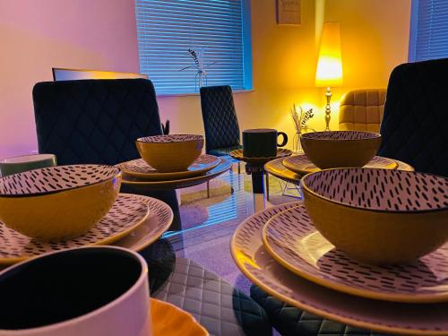 a room filled with bowls and plates on tables at GB Relocations Ltd - Award Winning Merridale Executive Apartment, Free Parking, Free WiFi, Free Netflix in Wolverhampton